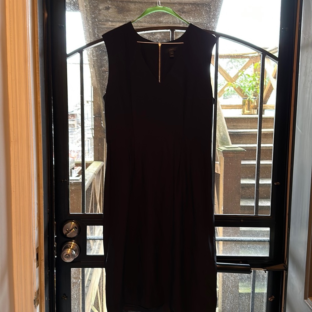 Black v neck with defined waistline, exposed back zipper.